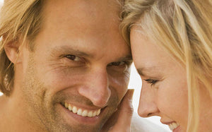 一名男性和一名女性頭靠著頭微笑。