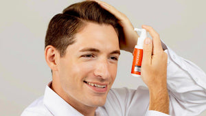 Man applying FOLIGAIN topical hair care for men to his scalp